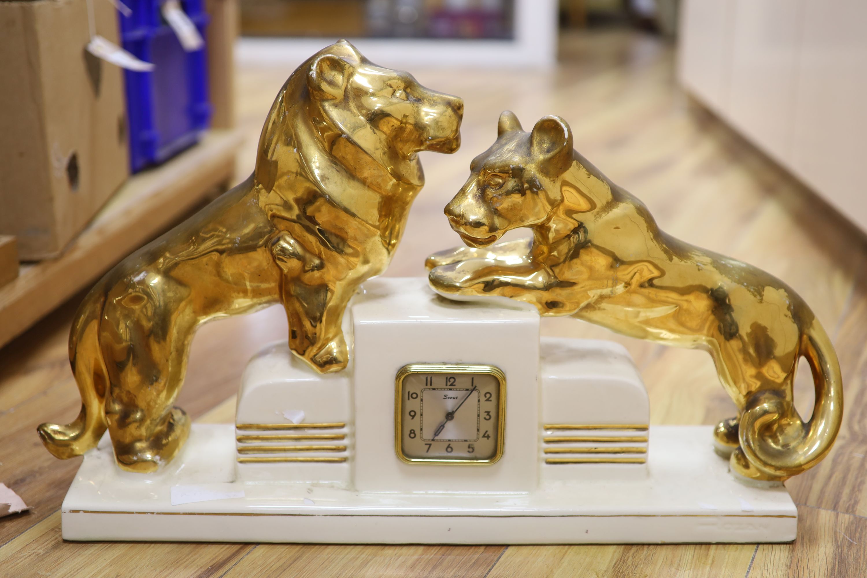 Two wooden Art Deco clocks and a ceramic clock modelled with lion cub